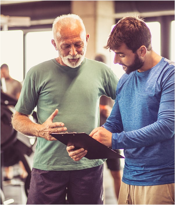 A Certified Personal Trainer shows his clipboard to his client